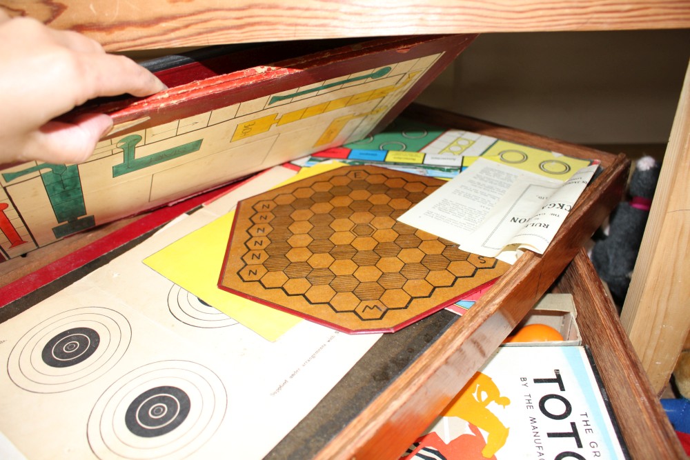 A quantity of assorted toys and games in a stacking three tier box